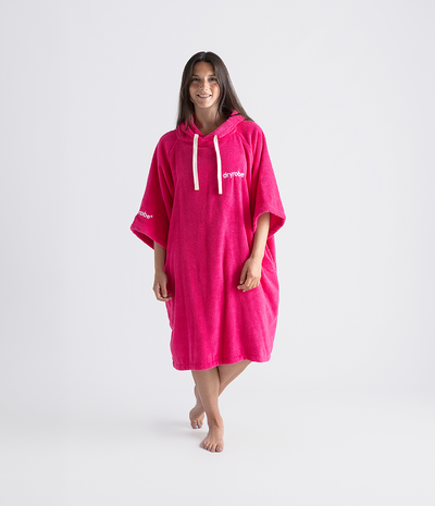 Person wearing a bright pink hooded towel robe on a white background
