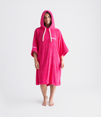 Person wearing a pink hooded towel robe with a brand logo on a white background