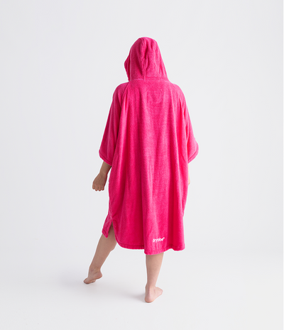 Person wearing a bright pink hooded towel robe on a white background