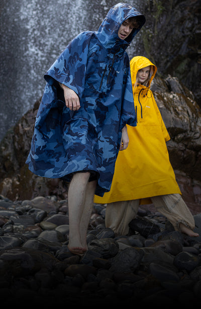 Man and woman stood in front of waterfall, wearing dryrobe® Waterproof Poncho with hoods up