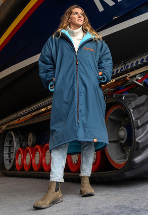 dryrobe Ambassador Lucy Campbell stood in front of a lifeboat, wearing RNLI dryrobe Advance Long Sleeve 