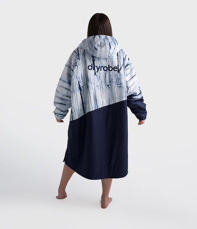 Person wearing a tie-dye robe with 'dryrobe' branding on a white background