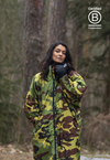 Woman stood in forest smiling at camera, wearing dryrobe® Advance Long Sleeve and dryrobe® Thermal Gloves