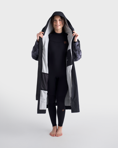 Person wearing a long dark coat with a hood on a white background