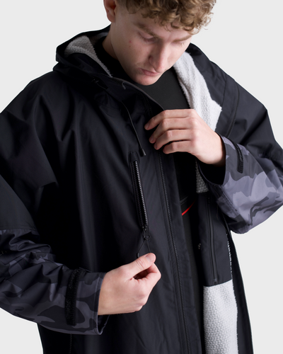 *MALE* Person wearing a black and camouflage jacket on a white background