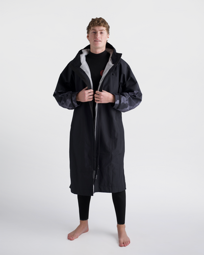 *MALE* Person wearing a long black coat with grey hood on a white background
