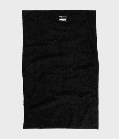 A black textured mat laid flat against a light gray background, featuring a small 'dryrobe' brand label near the top center.