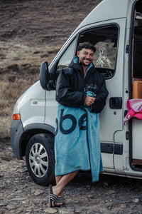 Man standing next to a van wearing a blue Dryrobe® and towel