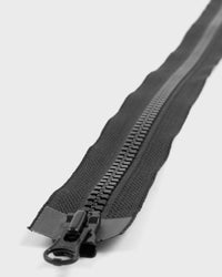 Close-up of a black zipper on a light grey background