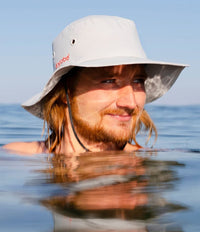 *MALE* in water wearing grey Dryrobe® water resistant wide brimmed hat 