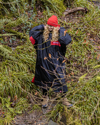 Woman walking through woods, wearing Black Red Red dryrobe® Advance Long Sleeve REMIX Range