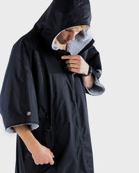 Man wearing Black Grey dryrobe® Advance Short Sleeve with hood up 