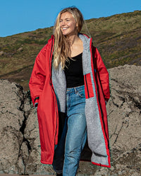 Woman walking on a beach, wearing Red Grey dryrobe® Advance Long Sleeve