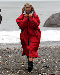 Woman walking away from the sea, wearing Red Grey dryrobe® Advance Long Sleeve 