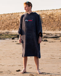 Man stood on a beach wearing Navy Blue Organic Towel dryrobe®