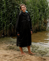 Woman stood by lake, wearing Stay Wild dryrobe® Advance