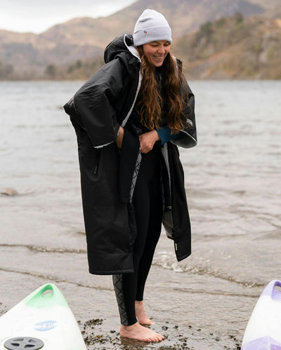 Adult female by lake wearing Dryrobe® black grey remix