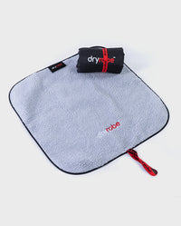 Rolled up Black Grey dryrobe® Change Mat, placed on top of one laid out flat  