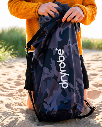 Black camo Dryrobe® compression bag on beach
