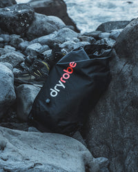 dryrobe® Compression Travel Bag on rocks on the beach 
