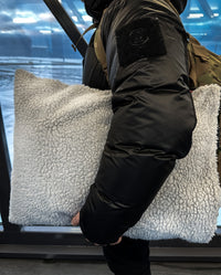 Person holding a stuffed dryrobe® Cushion Cover under their arm 