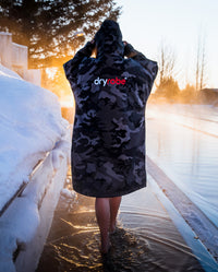 Person with back to the camera wearing Black Camo dryrobe® Advance Long Sleeve stood by icy pool