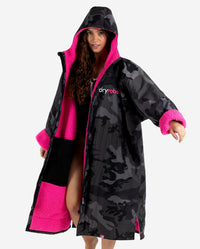 Woman wearing Black Camo Pink dryrobe® Advance Long Sleeve with hood up