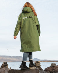 Woman stepping over rocks wearing Forest Green dryrobe® Advance Long Sleeve