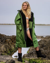 Woman in bikini stood on a beach, wearing Forest Green dryrobe® Advance Long Sleeve
