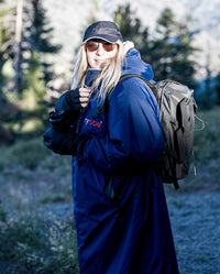 Woman carrying backpack and camera, wearing  Navy Grey dryrobe® Advance Long Sleeve