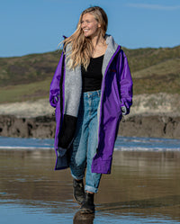 Woman walking on a beach, wearing Purple Grey dryrobe® Advance Long Sleeve 