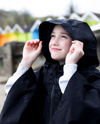 Close up of girl wearing Black Kids dryrobe® Waterproof Poncho with hood up 