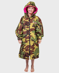 Girl smilng wearing Camo Pink dryrobe® Advance Kids Long Sleeve with hood up