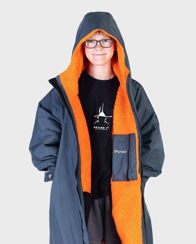Boy wearing dryrobe Advance Long Sleeve Change robe in Dark Grey Orange unzipped with hood up