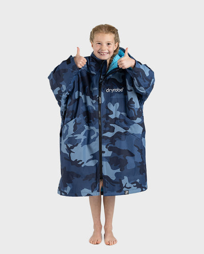 Girl wearing dryrobe Advance Long Sleeve Changing robe in Blue Camo Blue with zip up holding both thumbs up 