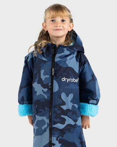 Girl wearing dryrobe Advance Long Sleeve Changing robe in Blue Camo Blue with ends of sleeves rolled up