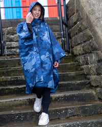 Girl walking down steps, wearing Blue Camo Kids dryrobe® Waterproof Poncho