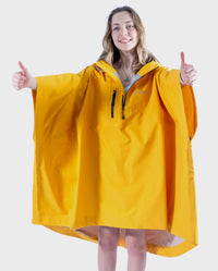 Girl wearing Yellow Kids dryrobe® Waterproof Poncho holding her thumbs up 