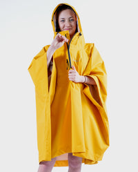 Girl wearing Yellow Kids dryrobe® Waterproof Poncho doing up the zip 