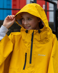 Close up of girl wearing Yellow Kids dryrobe® Waterproof Poncho with hood up 