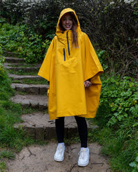 Girl stood on steps wearing Yellow Kids dryrobe® Waterproof Poncho
