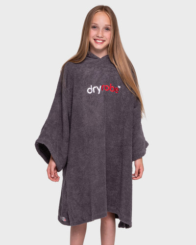 Girl smiling wearing Kids Towel Robe in Slate Grey with hood down