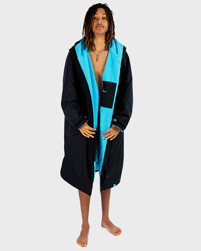 Person wearing a black and blue dryrobe on a white background