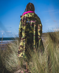 *MALE* standing in sand dunes wearing Camo Pink dryrobe® Advance Long Sleeve