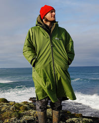 *MALE* stood in front of the sea facing camera, wearing Forest Green dryrobe® Advance Long Sleeve