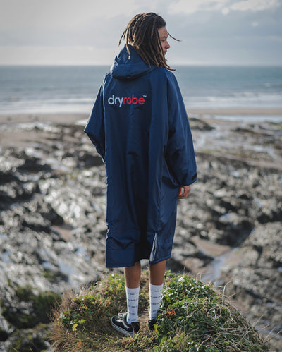 *MALE* wearing Navy Grey dryrobe¬Æ Advance Long Sleeve, while standing on a cliff facing the sea