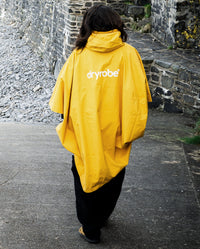*MALE* walking away from camera wearing  Yellow dryrobe® Waterproof Poncho