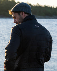 Man stood by a lake, wearing dryrobe® Mid-Layer Jacket