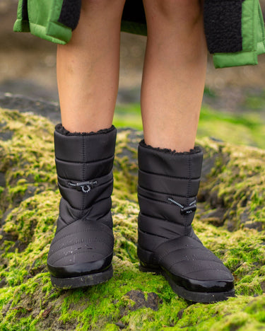 1| Person stood on rocks covered in seaweed, wearing dryrobe¬Æ Eco Thermal Boots