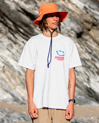 1|Man stood in front of rocks on a beach, wearing Orange dryrobe® Quick Dry brimmed hat